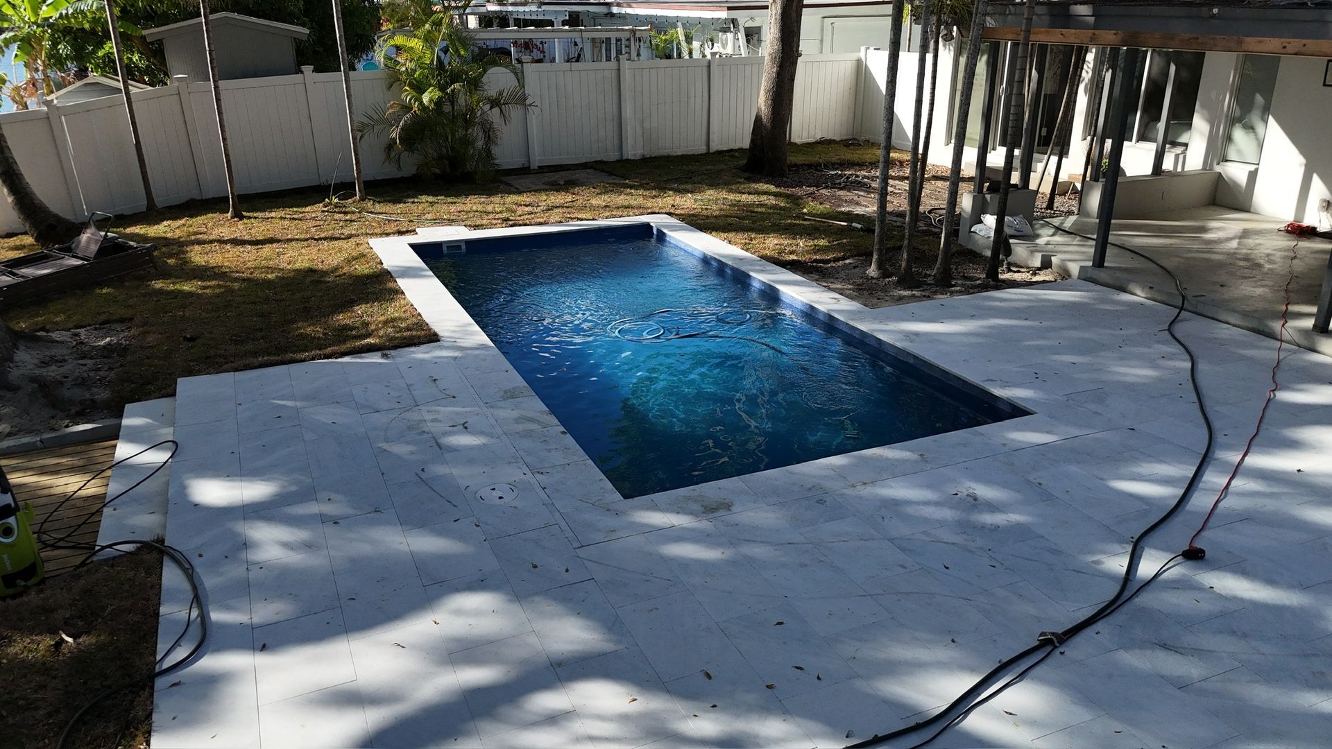 A swimming pool is being built in the backyard of a house.