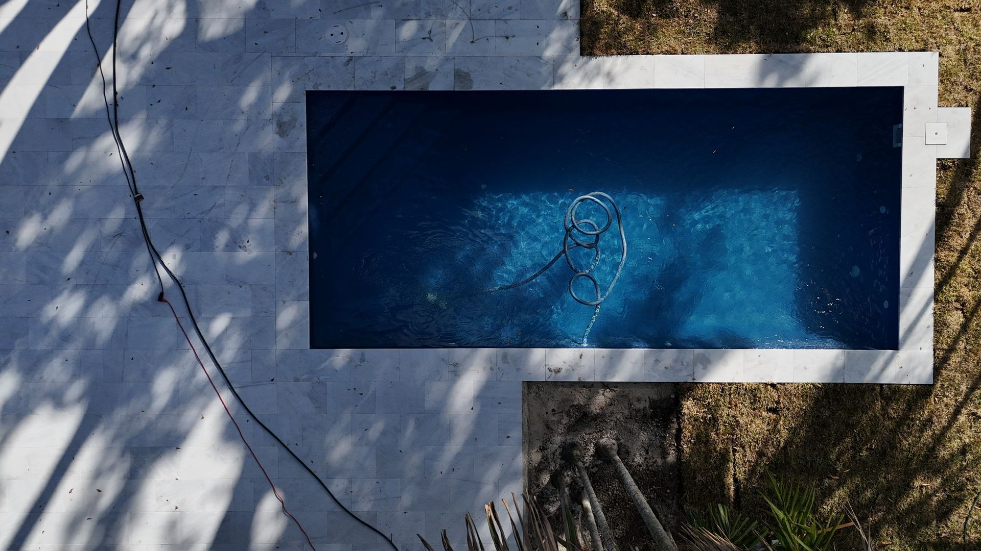 An aerial view of a swimming pool surrounded by trees.