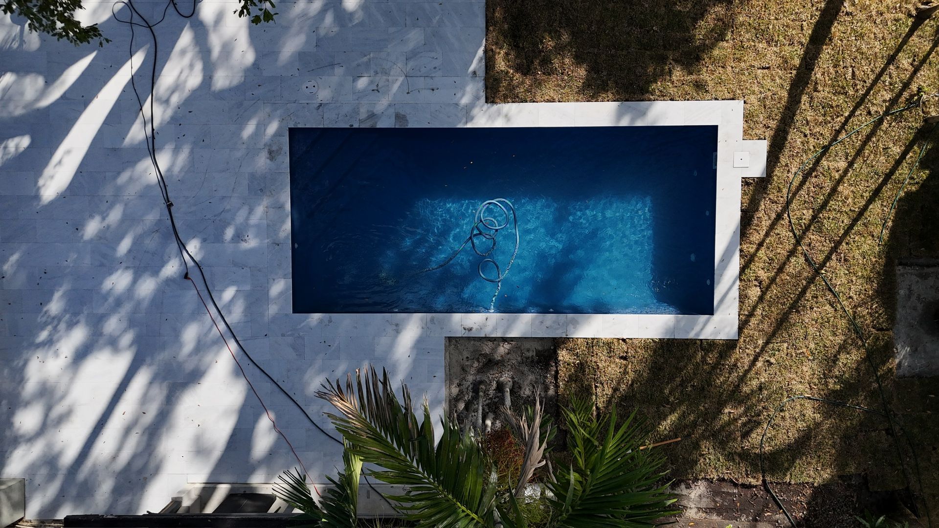 An aerial view of a swimming pool surrounded by trees