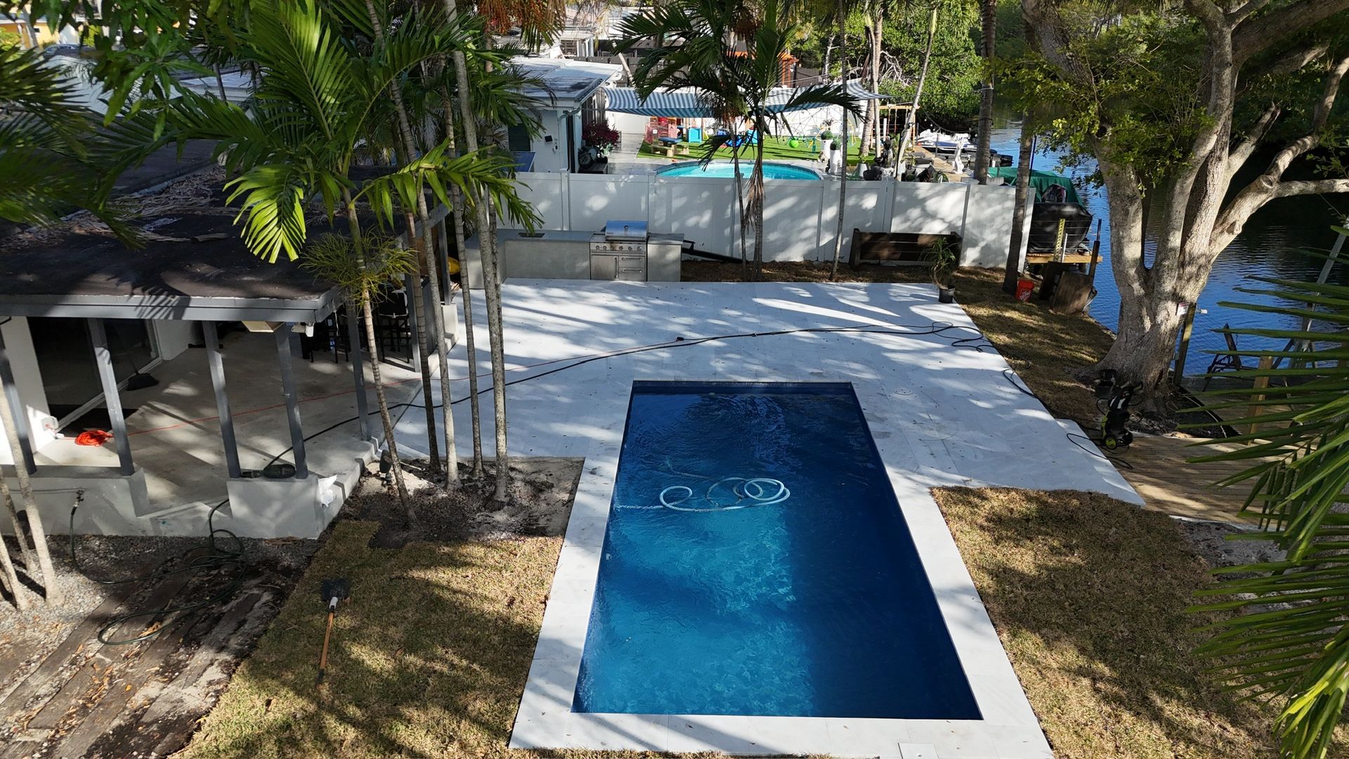 An aerial view of a swimming pool in the backyard of a house.