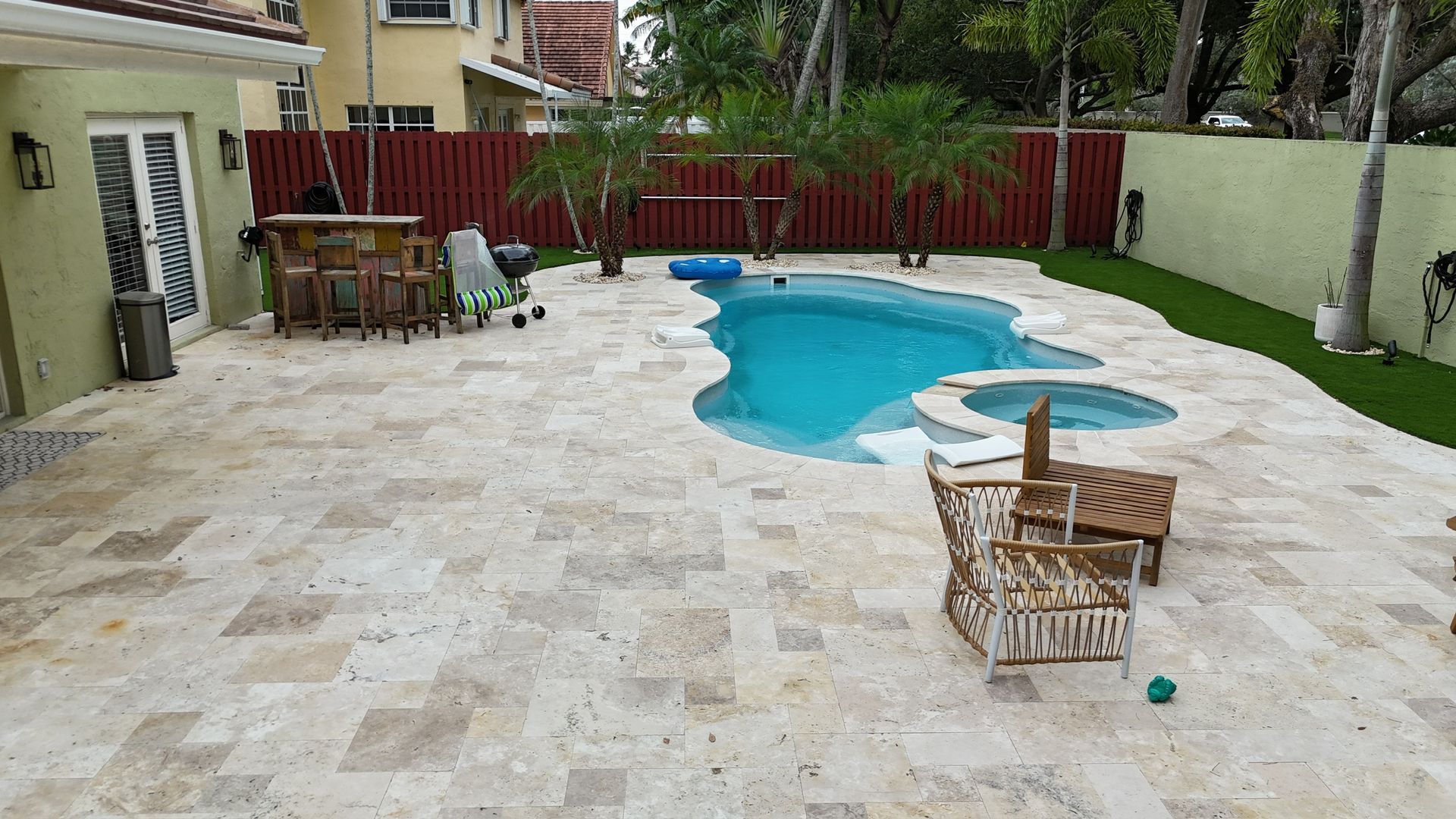 There is a large swimming pool in the backyard of a house.