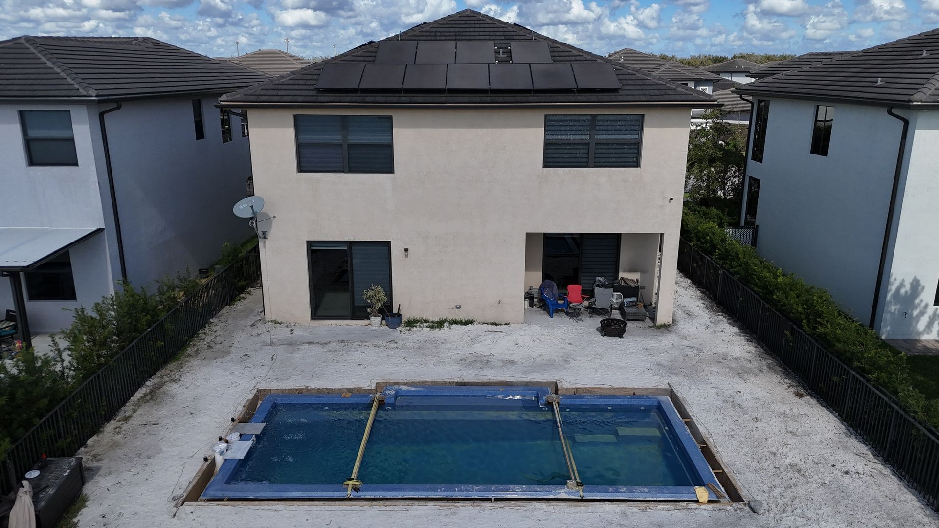 An aerial view of a house with a swimming pool in front of it