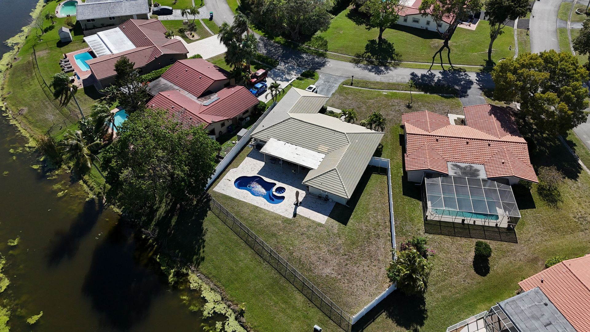 An aerial view of a residential area with houses and a pool.