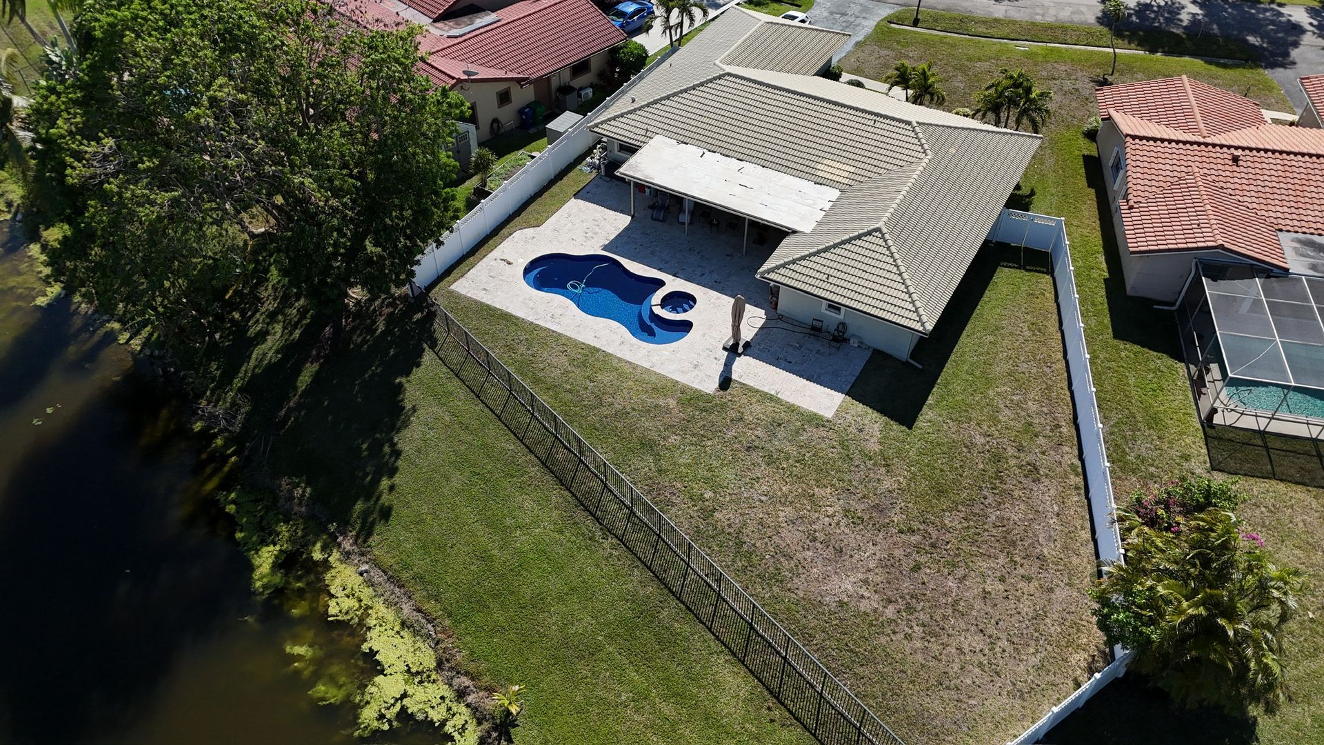 An aerial view of a house with a pool in the backyard.