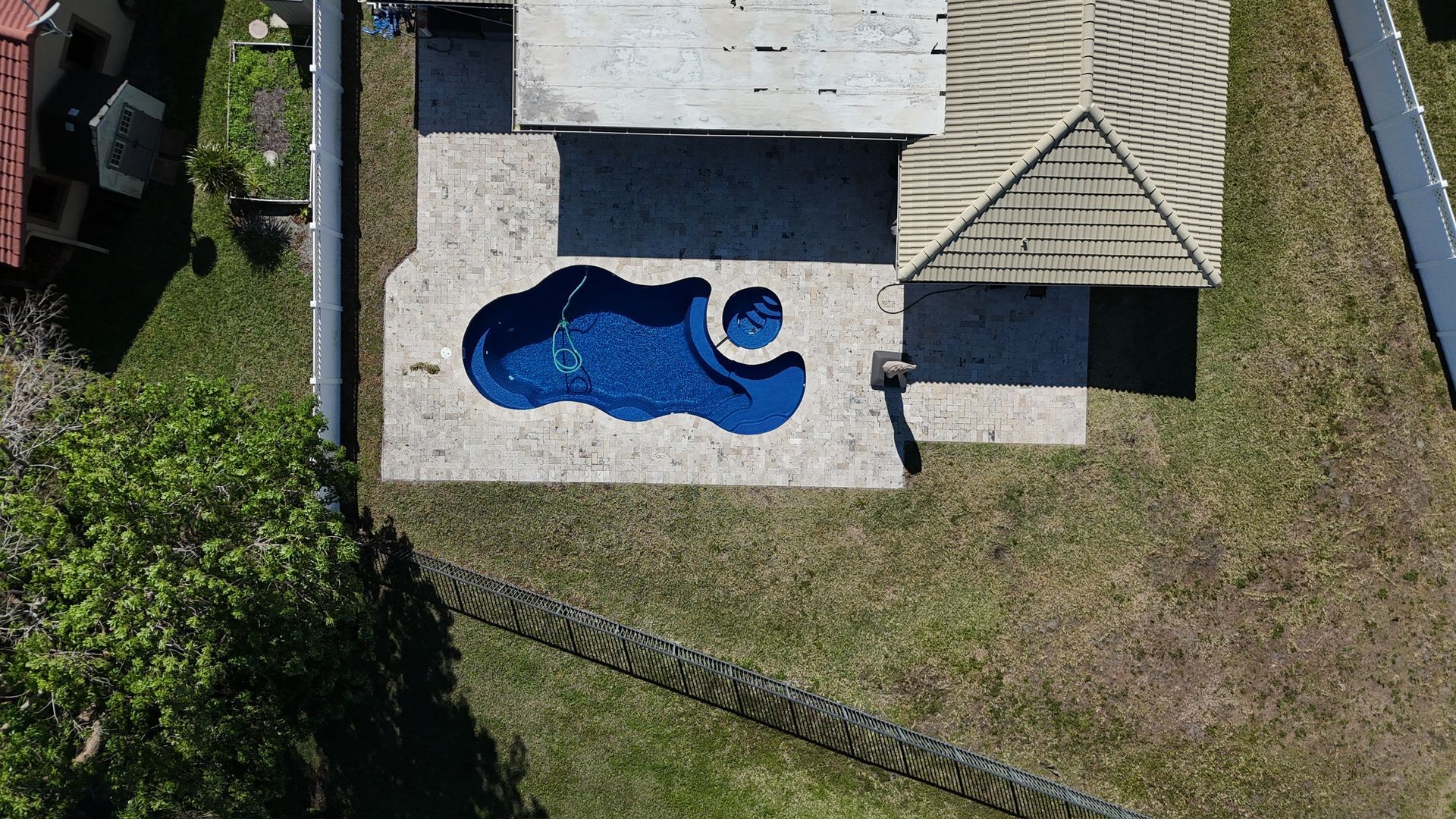 An aerial view of a house with a pool in the backyard.