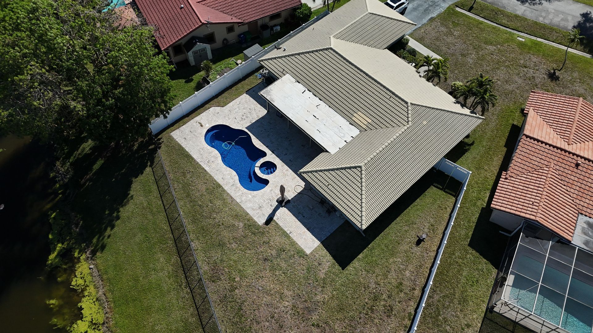 An aerial view of a house with a pool in the backyard
