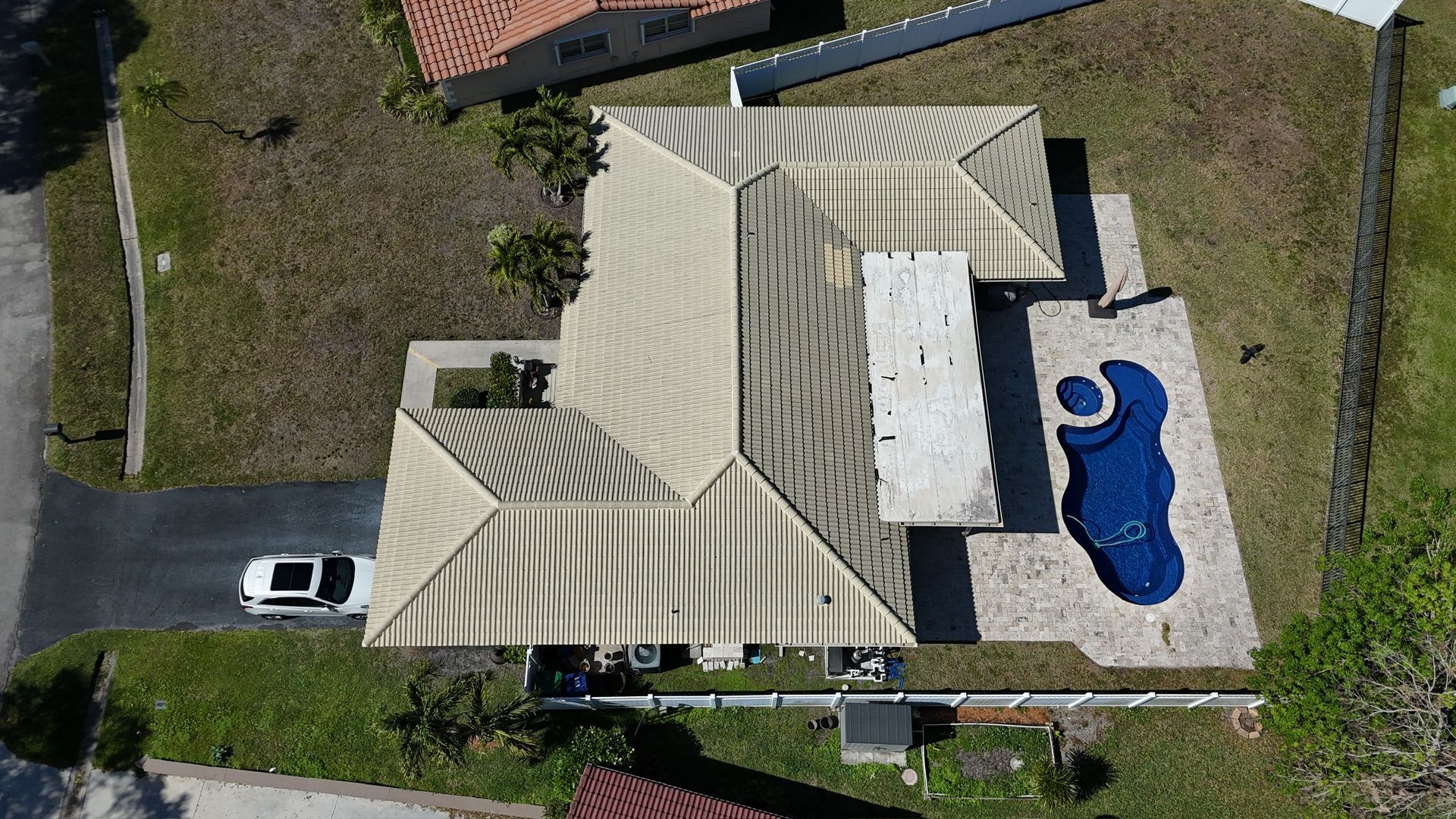 An aerial view of a house with a pool in the backyard