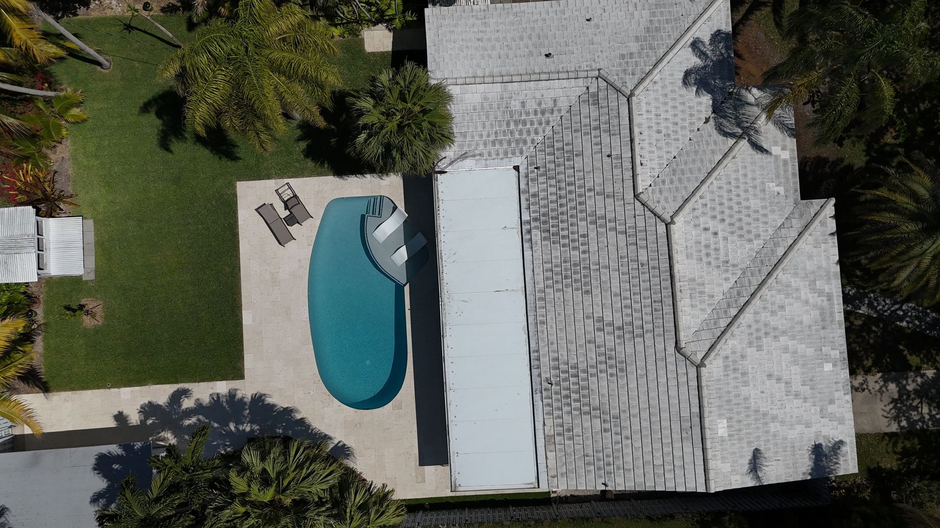 An aerial view of a house with a pool in the backyard.