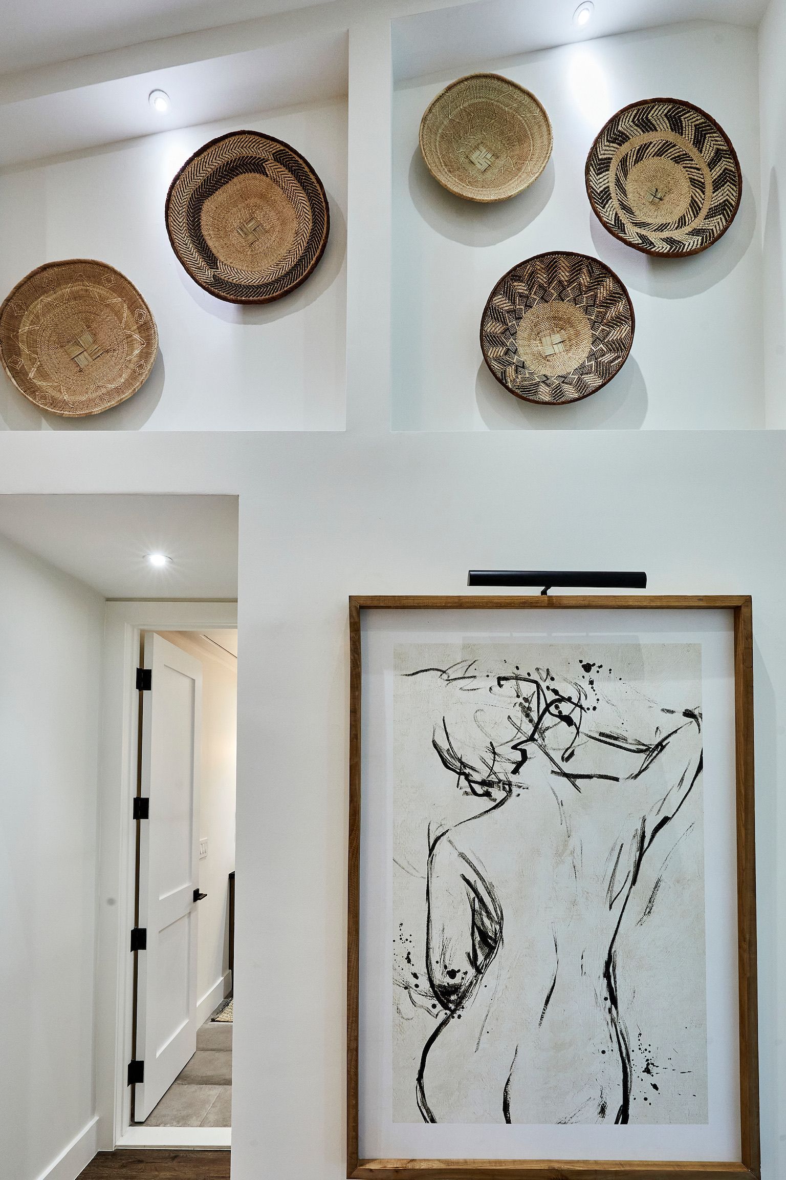 A picture of a woman 's back is hanging on a wall.