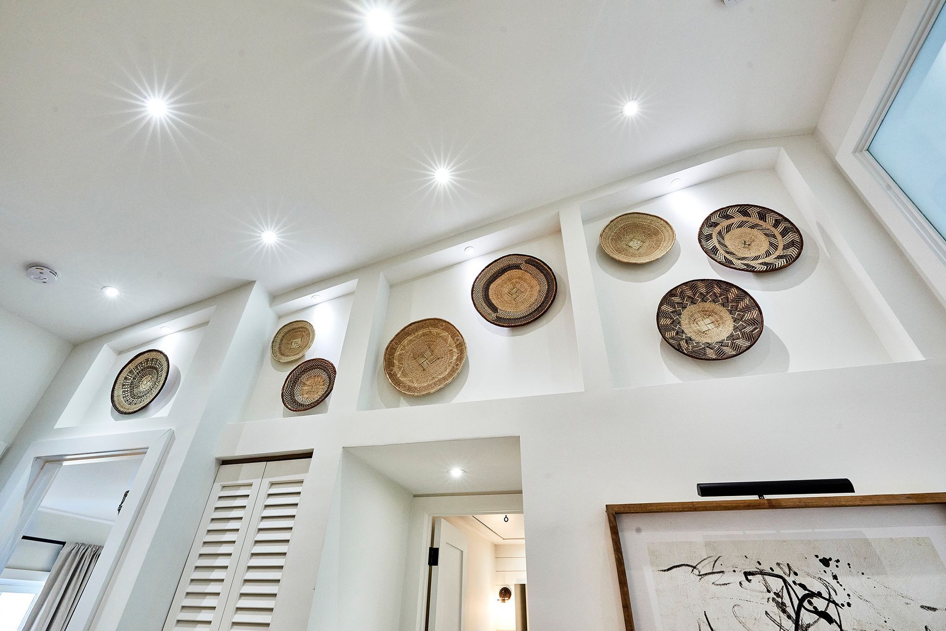 A room with a picture on the wall and baskets on the wall