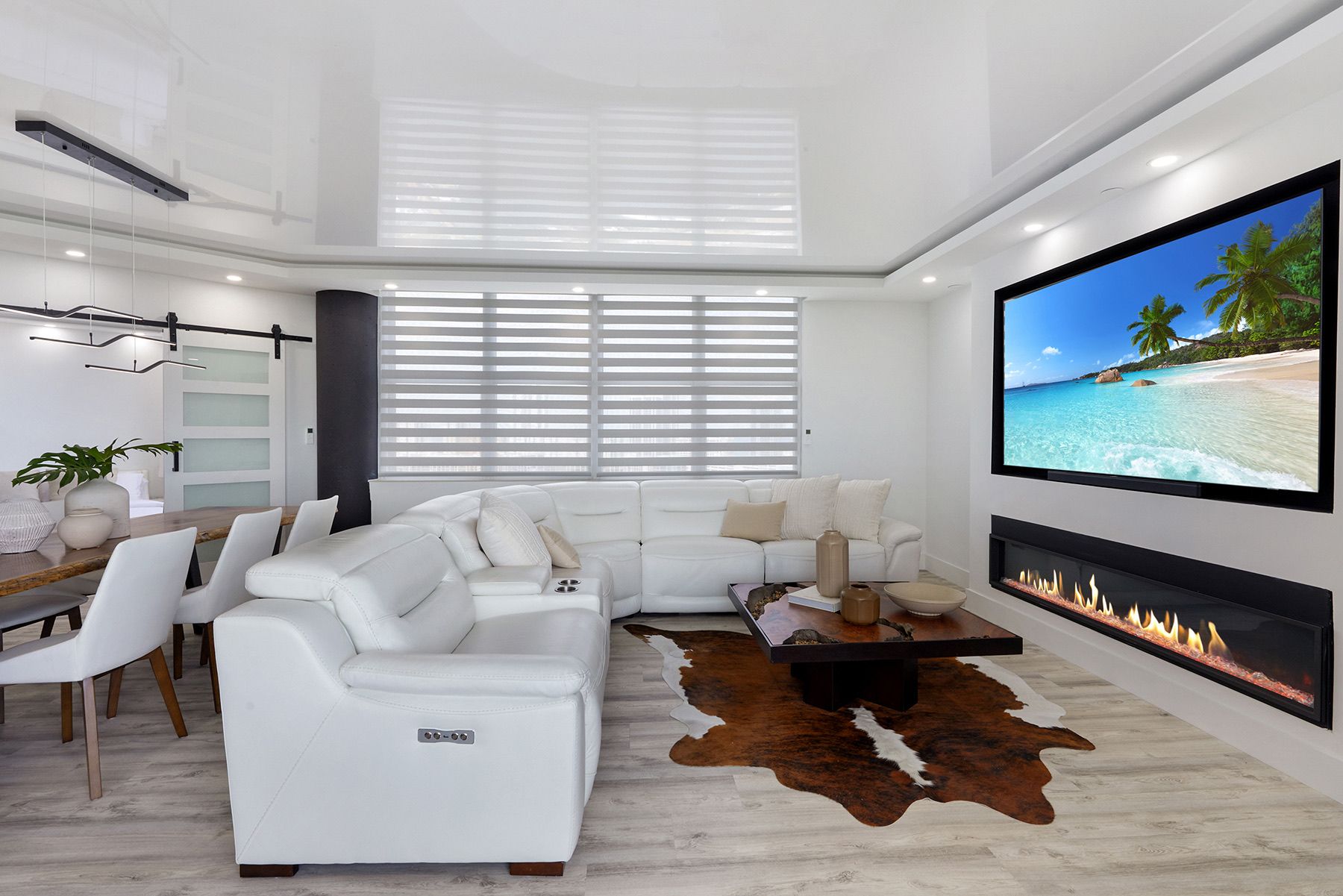 A living room with a couch , chairs , coffee table and a flat screen tv.