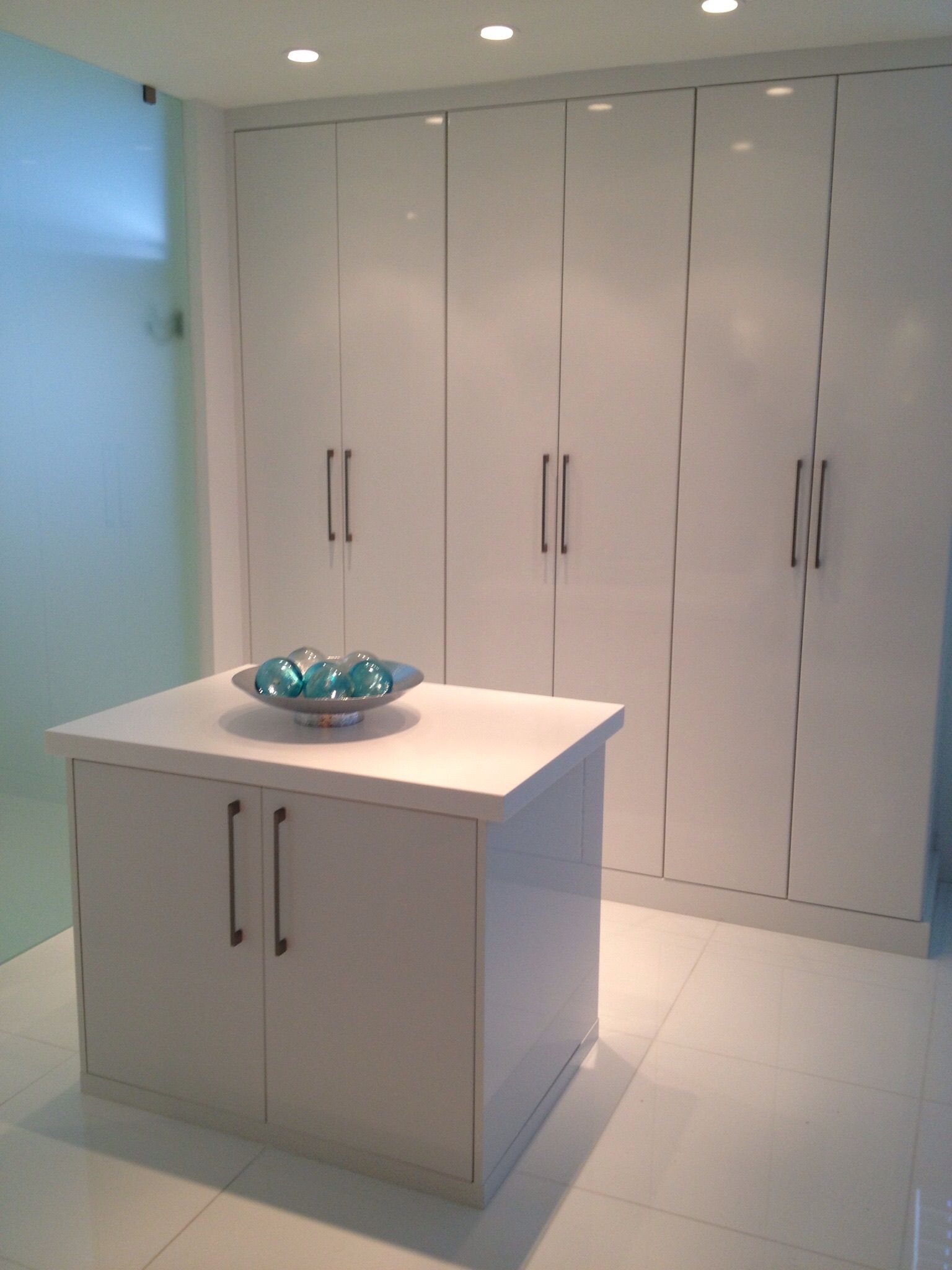 A white cabinet with a blue bowl on top of it