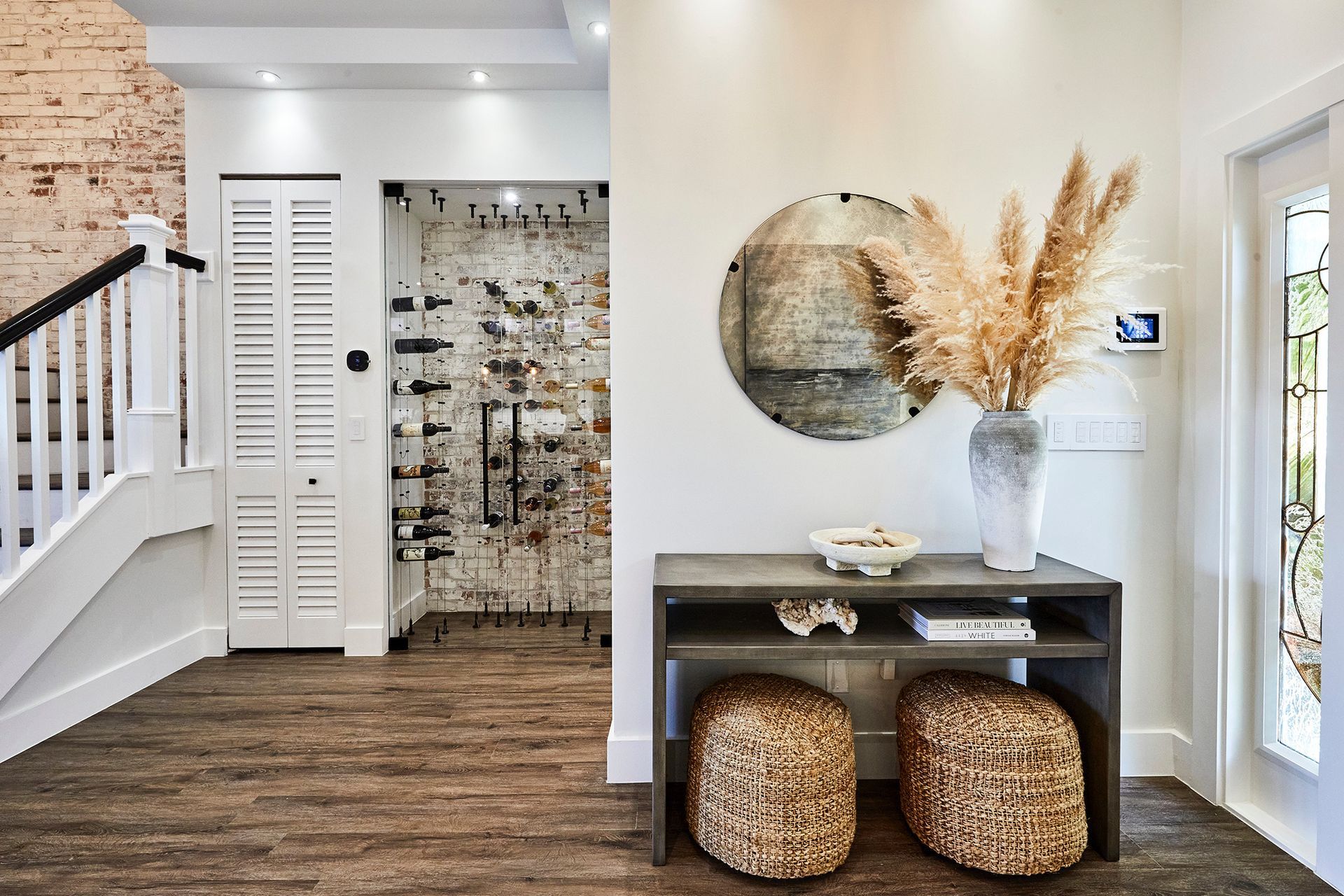 A living room with a table , ottomans and a mirror.