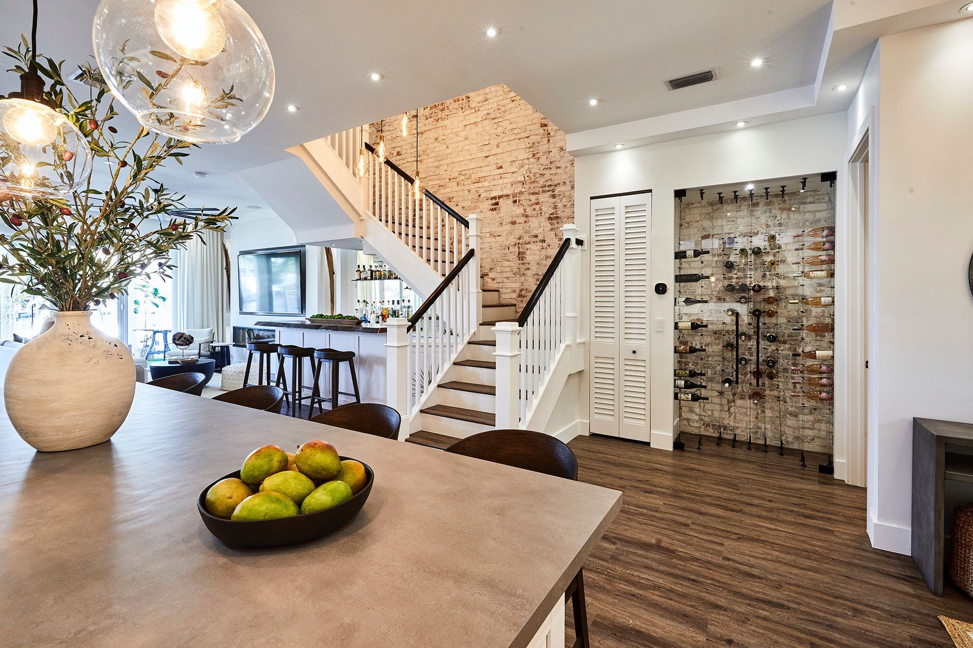There is a bowl of fruit on the table in the kitchen.
