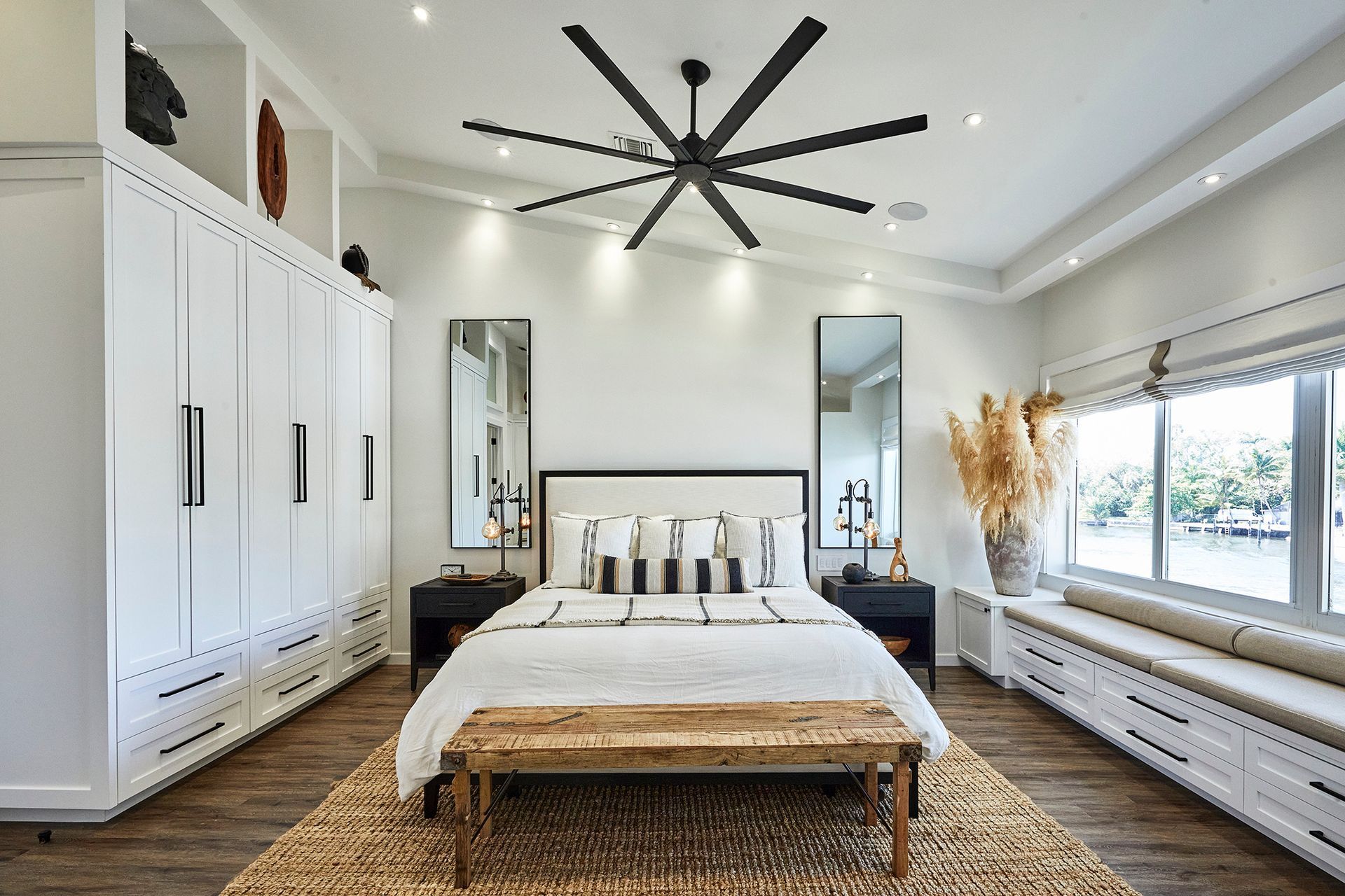 A bedroom with a large bed and a ceiling fan.