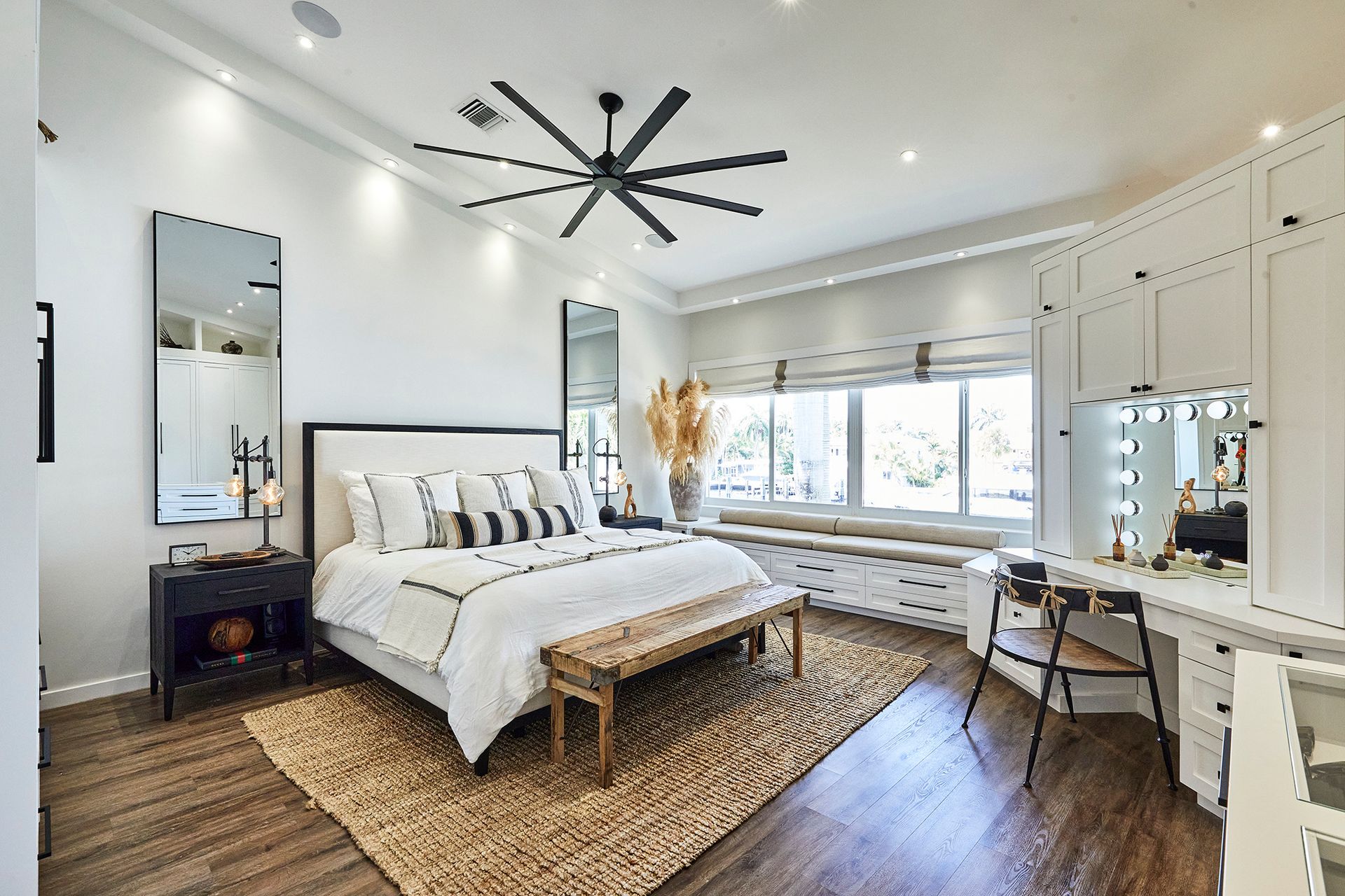 A bedroom with a large bed and a ceiling fan.