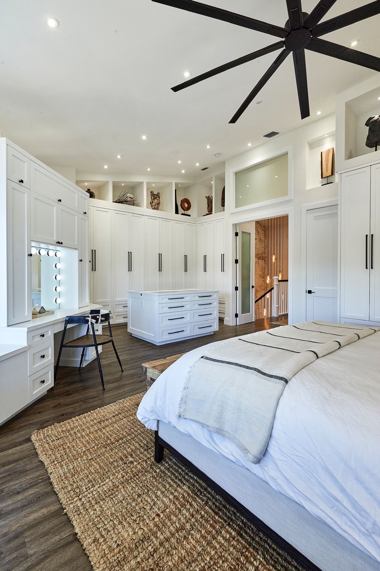 A bedroom with a large bed and a ceiling fan.