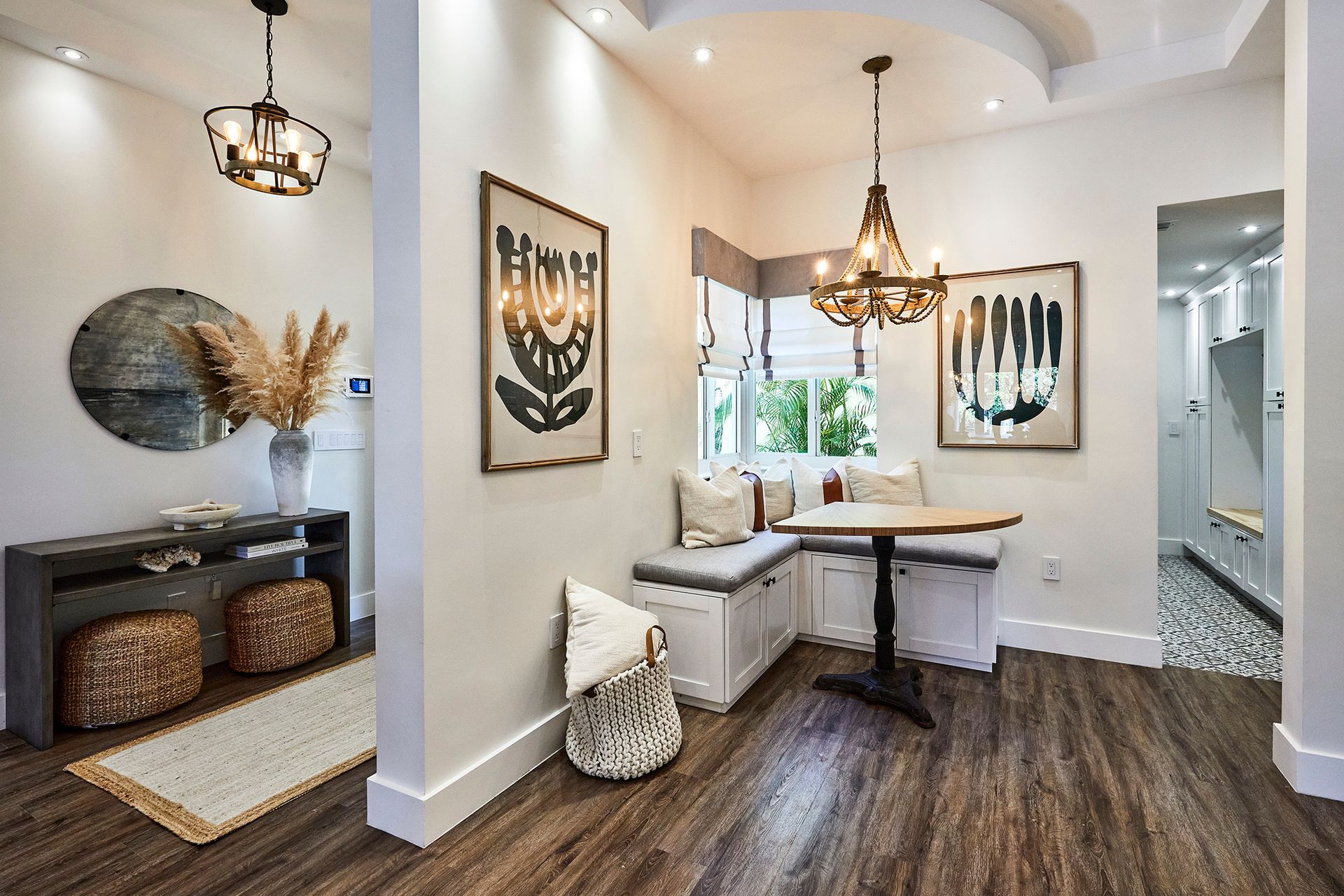 A dining room with a table , benches , and a mirror.
