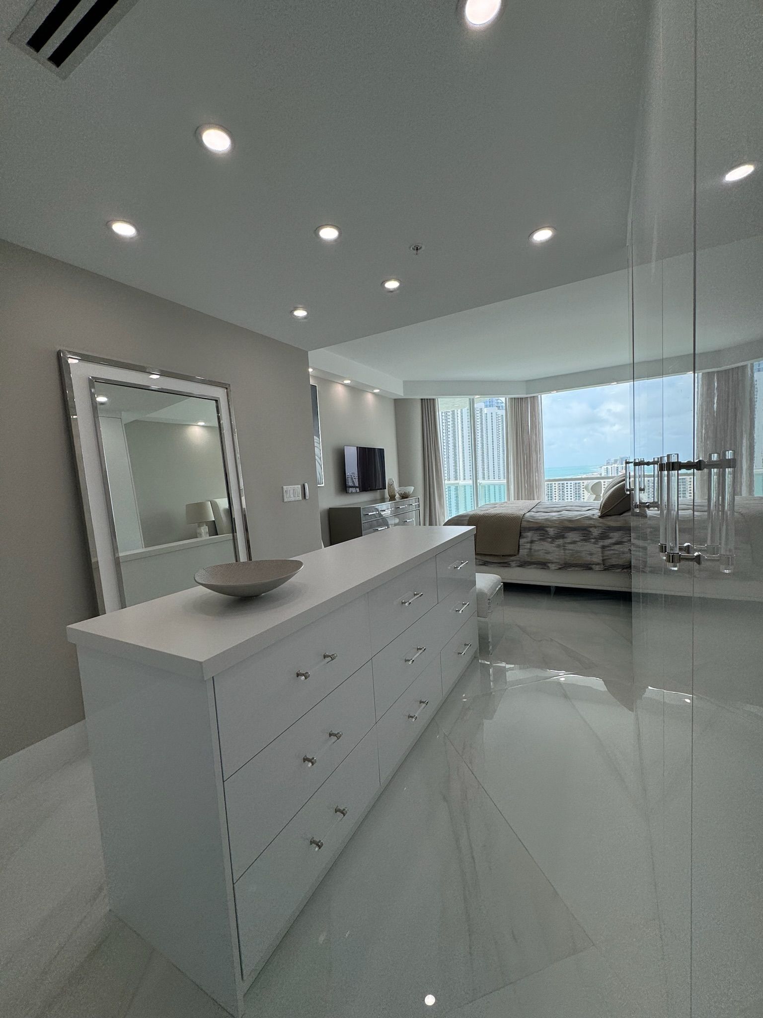 A living room with a large white dresser and a large mirror.