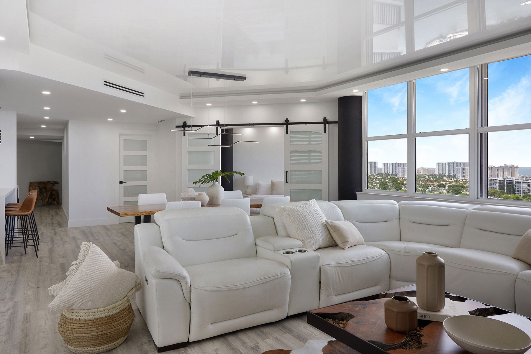 A living room with a white sectional couch and a large window.