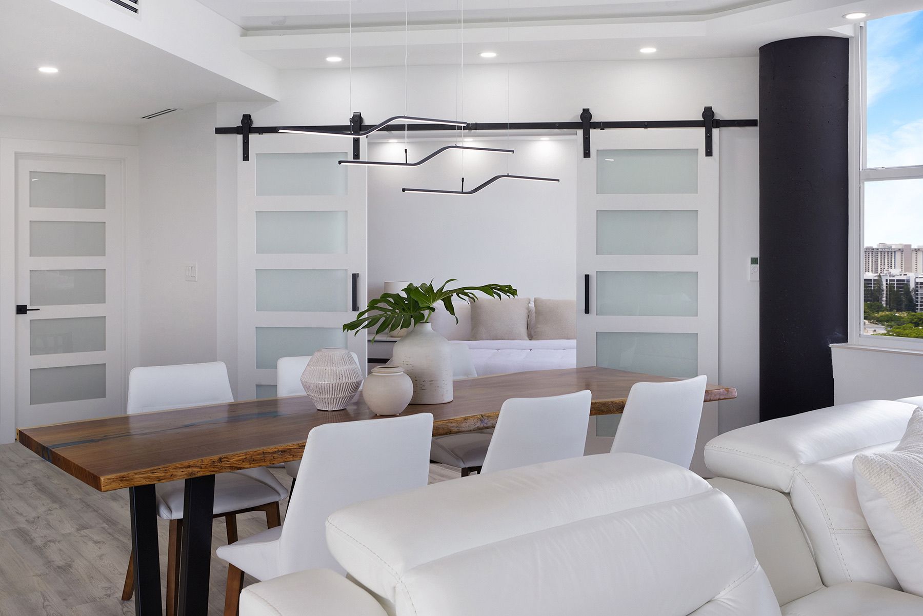 A dining room with a wooden table and white chairs