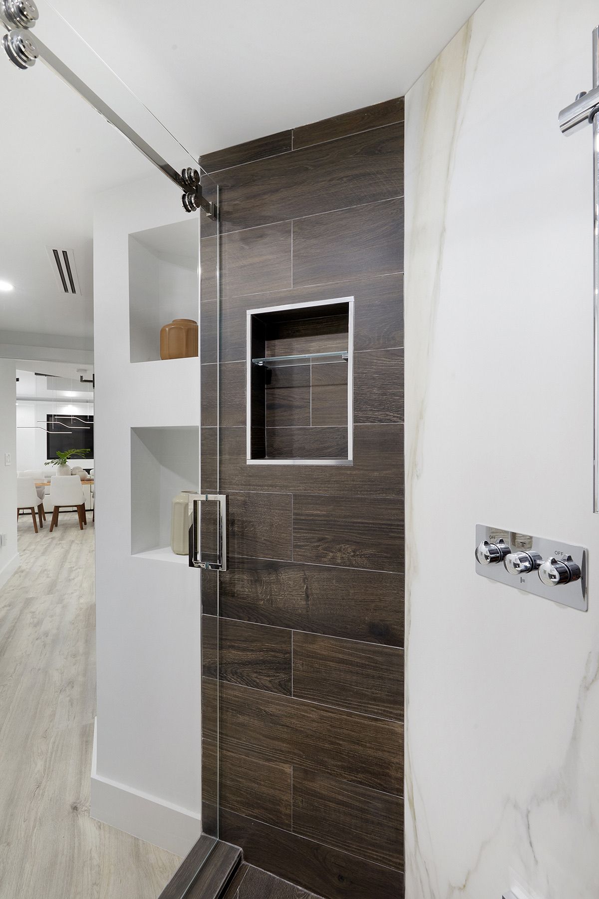 A bathroom with a walk in shower and a sliding glass door.