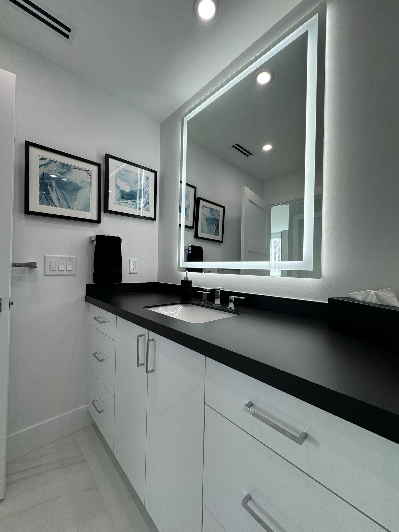 A bathroom with a large mirror and a sink