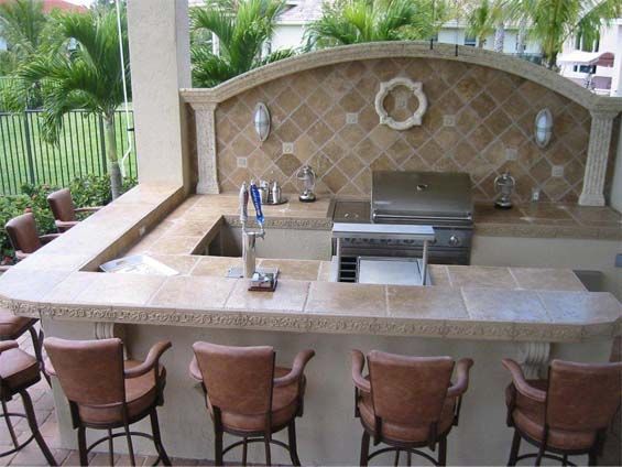 An outdoor kitchen with a sink and a grill