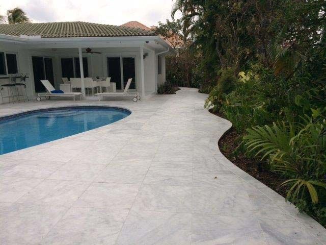 A white house with a swimming pool in front of it