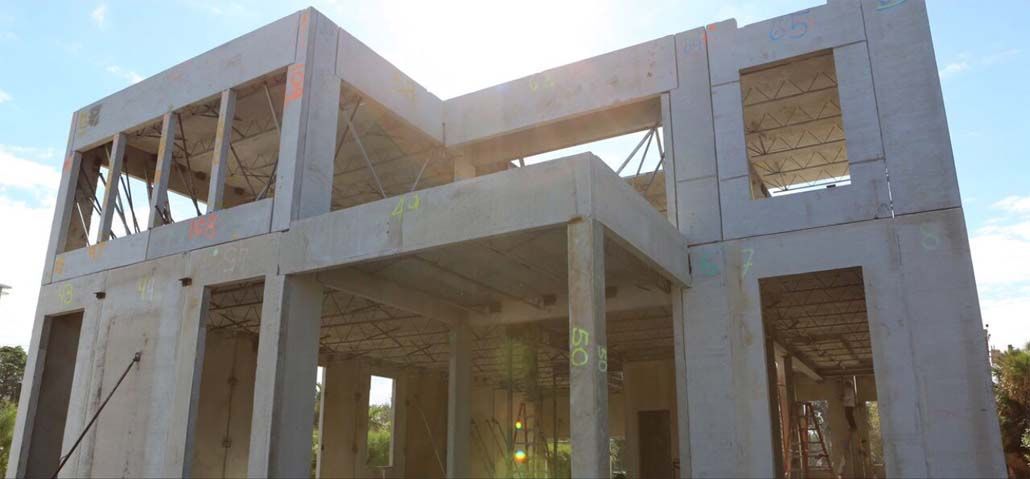 A large white house is being built with a blue sky in the background.