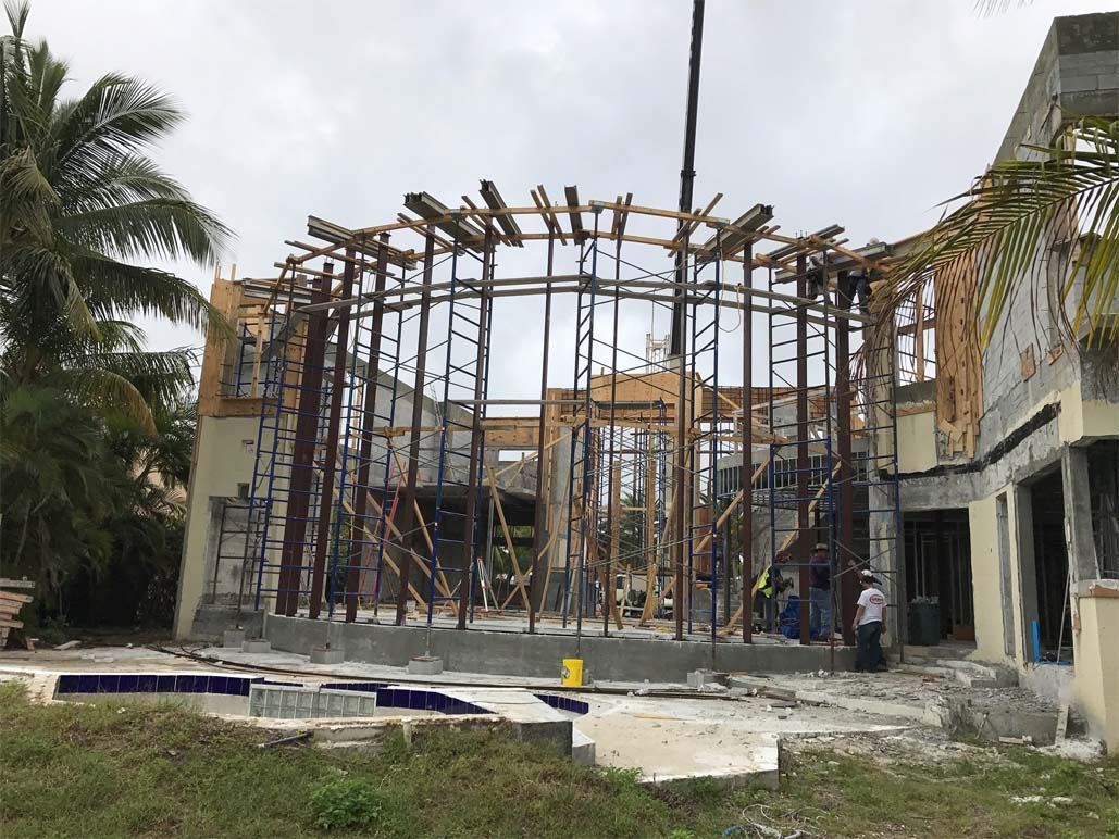 A large building under construction with a crane in the background.