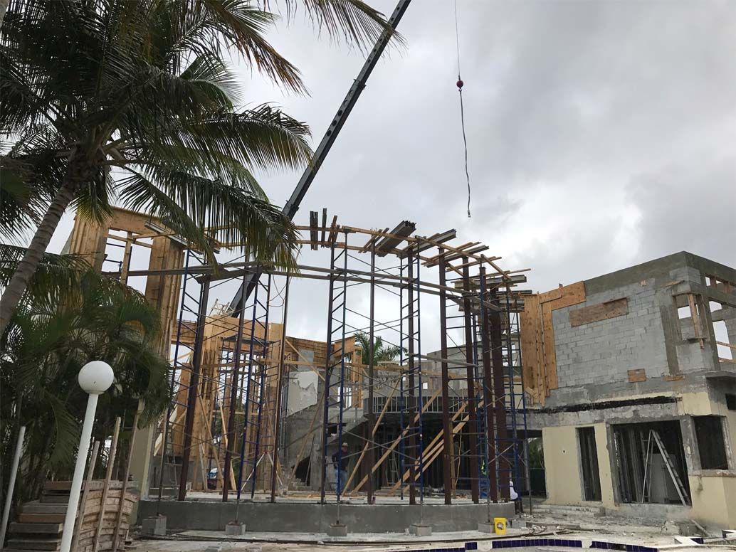 A large building under construction with a crane in the foreground.