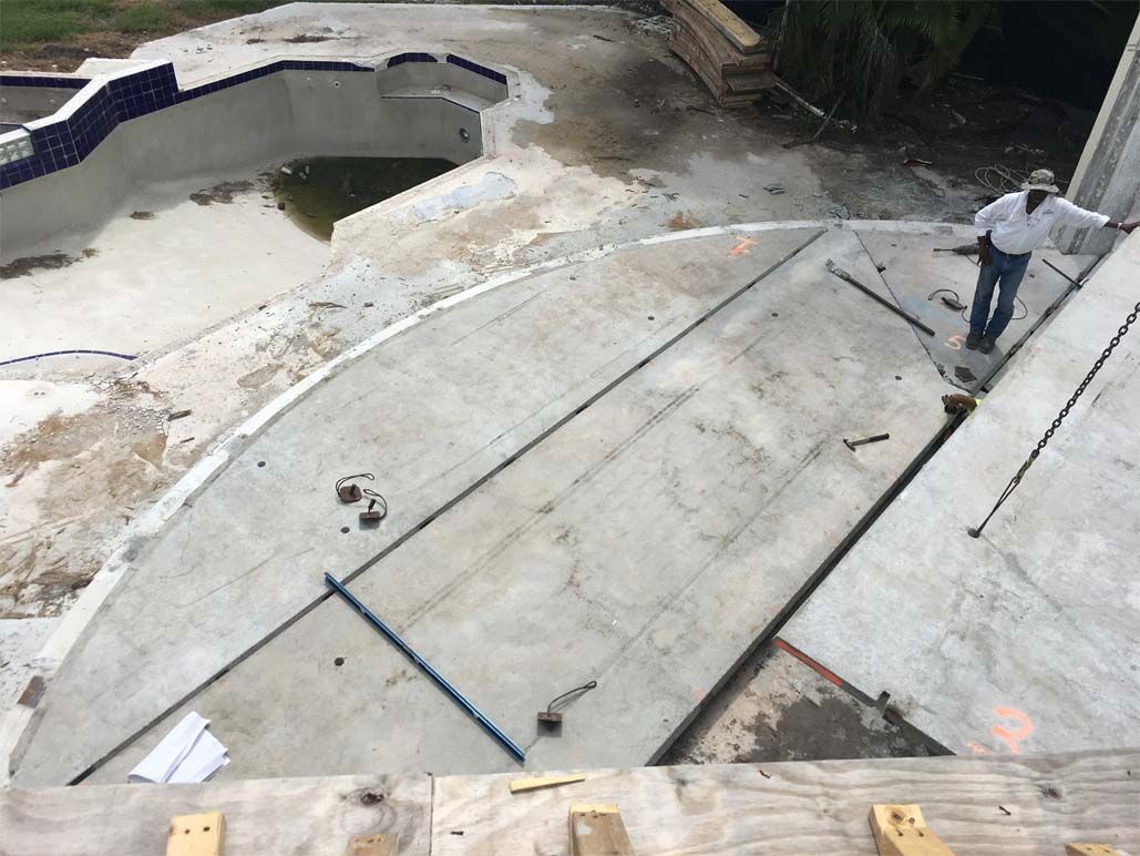 A man is standing in front of a swimming pool under construction