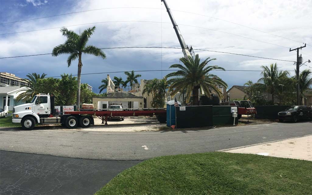A truck with a crane on the back is parked on the side of the road.