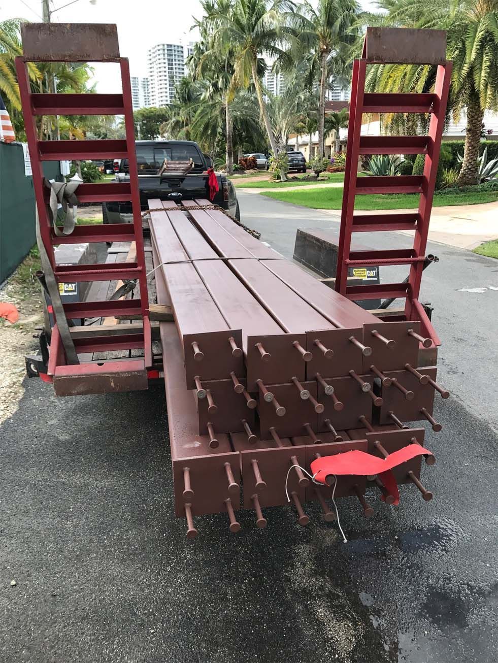A truck is carrying a stack of wooden boards on a trailer.