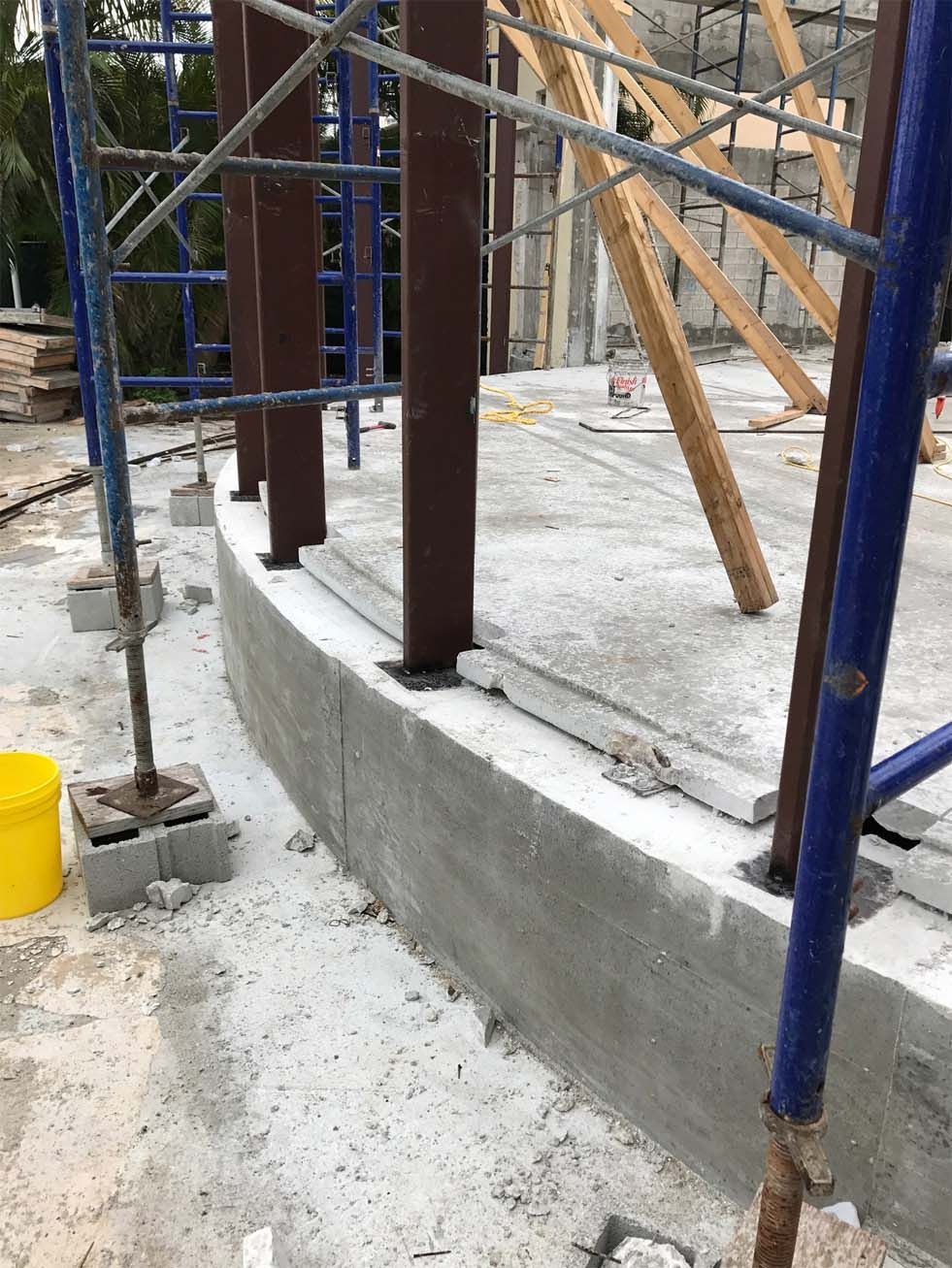 A construction site with scaffolding and a yellow bucket.