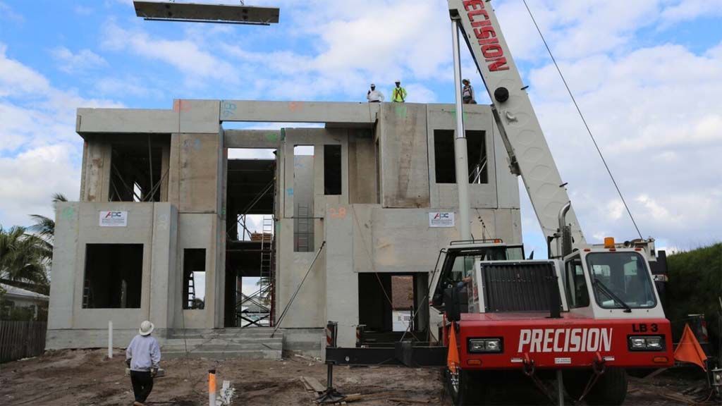 A red precision truck is parked in front of a building under construction