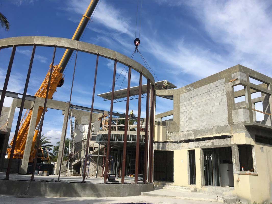 A large building under construction with a crane in the foreground.