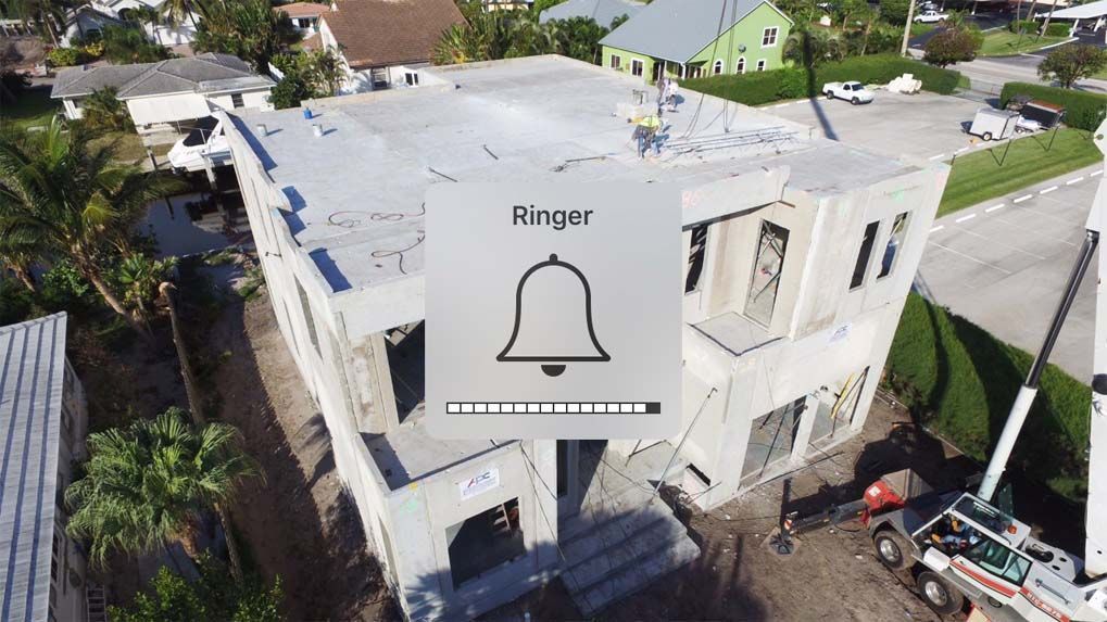 An aerial view of a building under construction with a bell on it