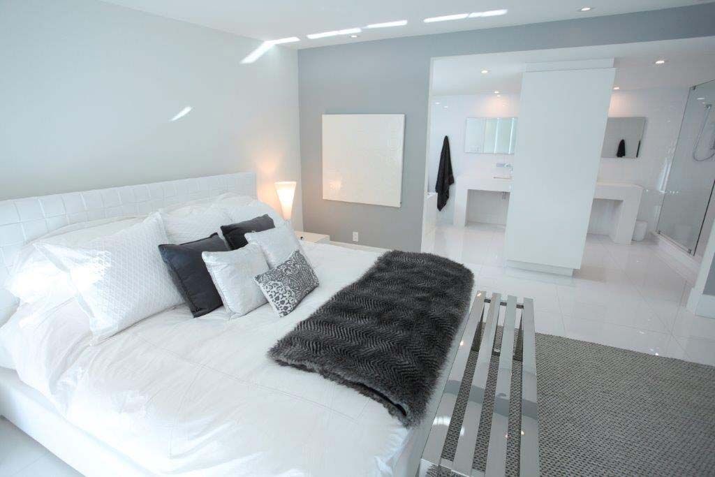 A bedroom with a large bed and a bench.