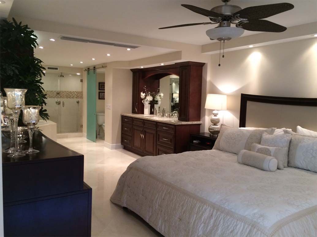 A bedroom with a large bed and a ceiling fan