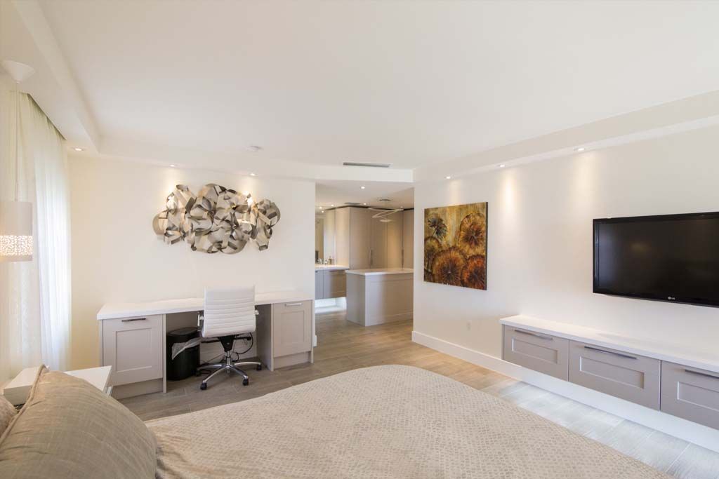 A living room with a desk and a flat screen tv