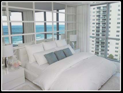 A bedroom with a large bed and a view of the ocean