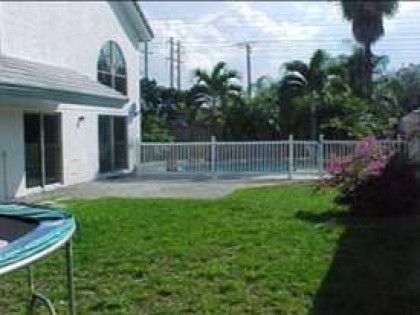 There is a trampoline in the backyard of a house.