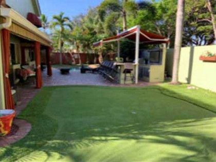A backyard with a green lawn and a canopy.