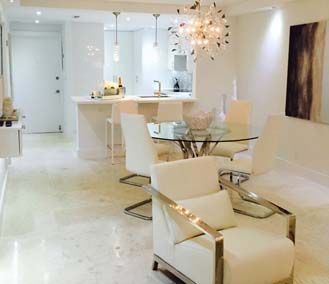 A living room with a dining table and chairs and a chandelier.