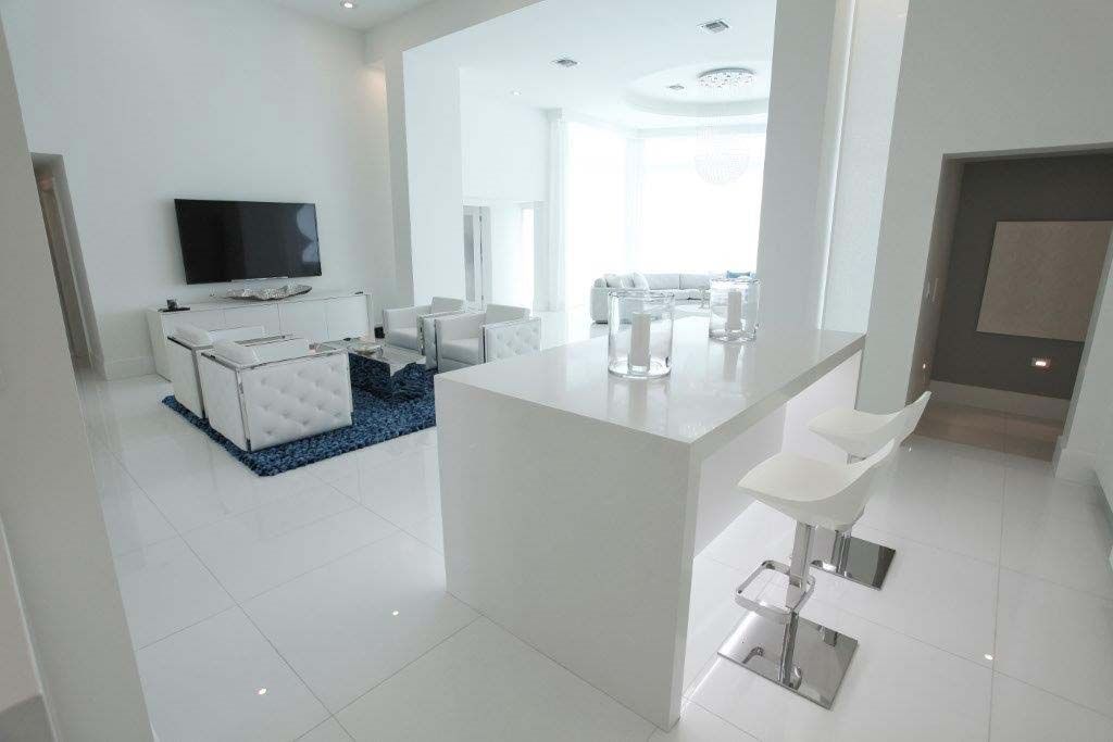A white living room with a bar and a television.