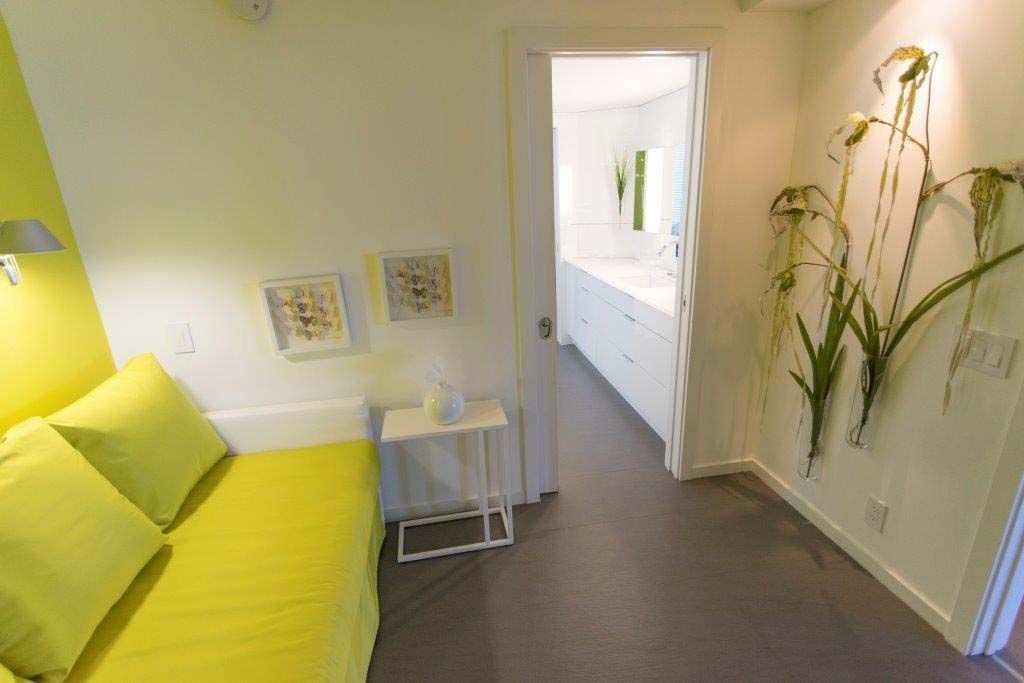 A bedroom with yellow walls and a yellow couch