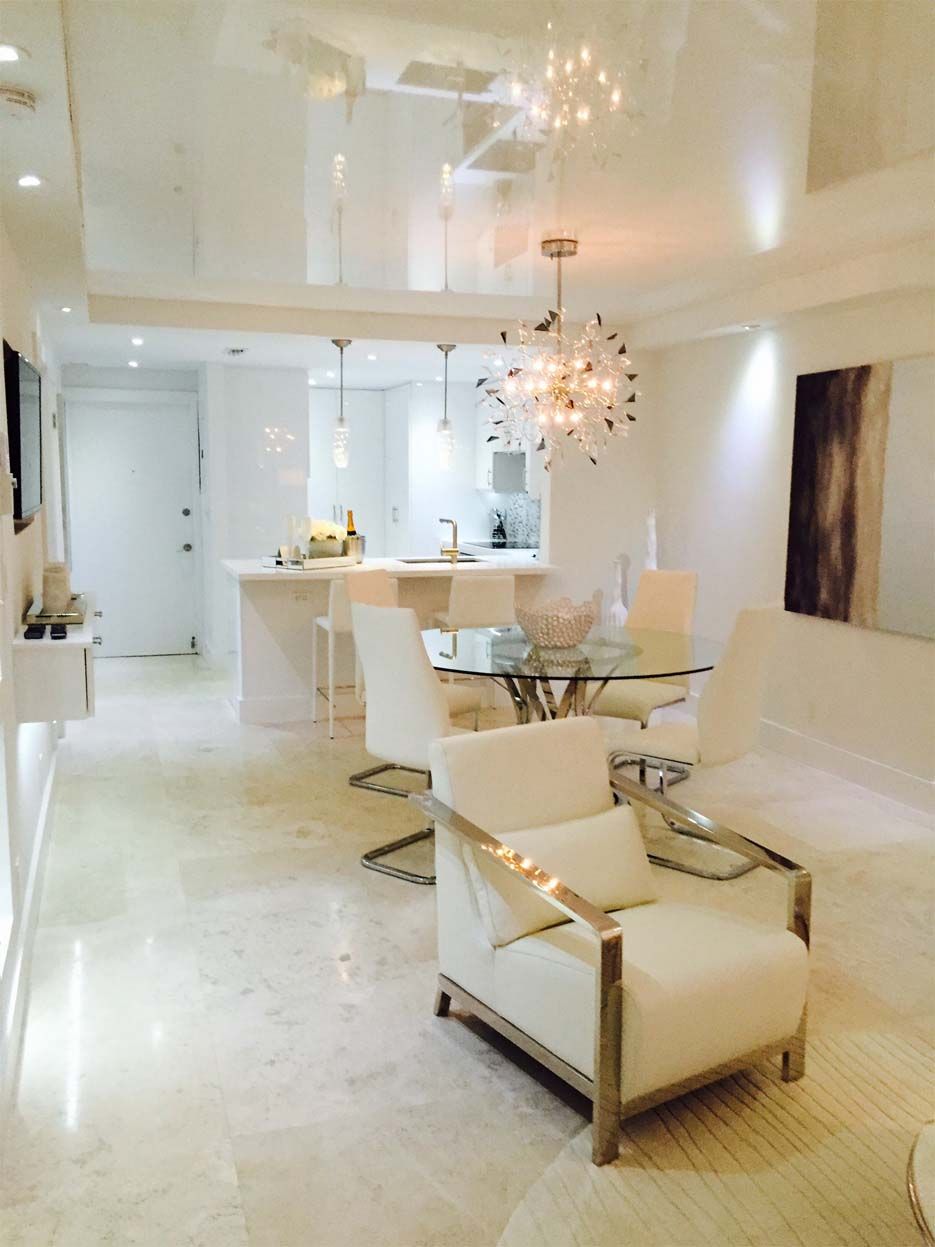 A living room with a white chair and a glass table