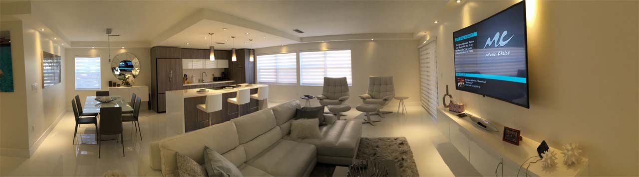 A living room with a couch and a flat screen tv on the wall.